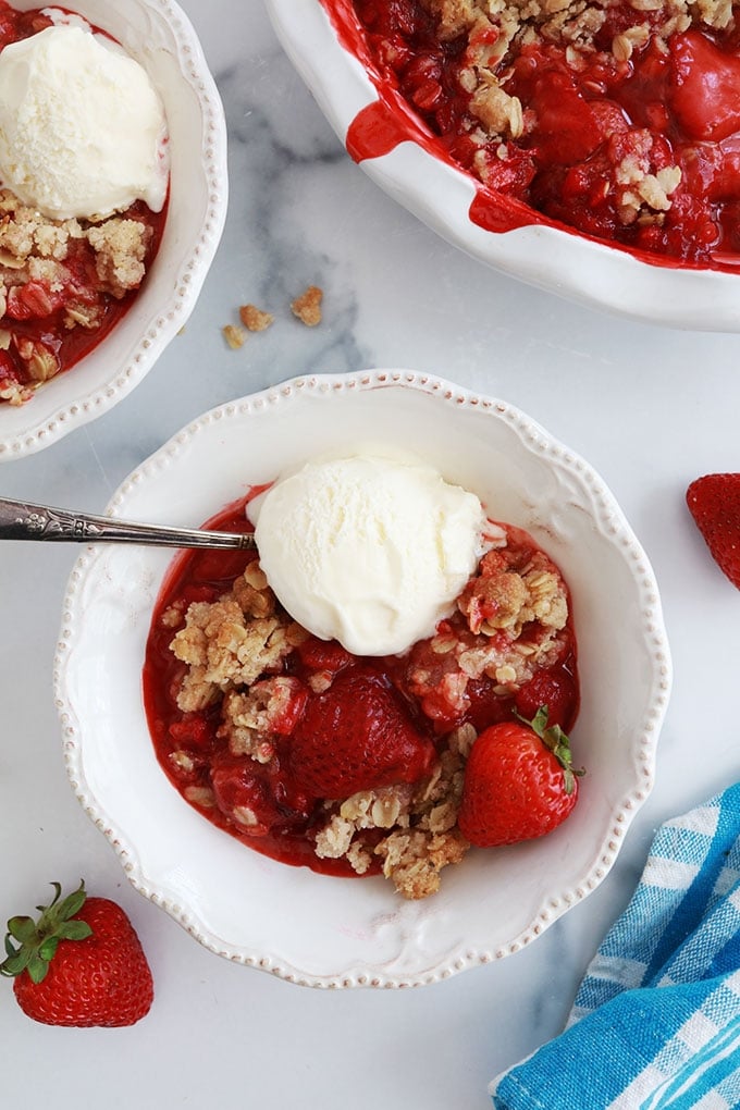 Crumble aux fraises et avoine dans des bols avec de la glace à la vanille et dans le moule de cuisson