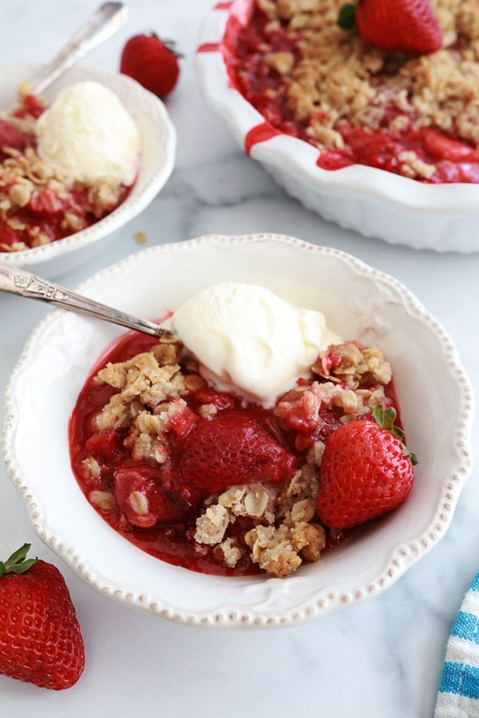 Crumble aux fraises et avoine dans des bols avec de la glace à la vanille et dans le moule de cuisson