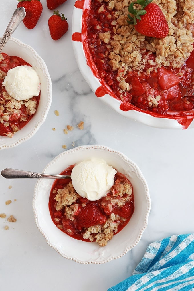 Crumble aux fraises et avoine dans des bols avec de la glace à la vanille et dans le moule de cuisson