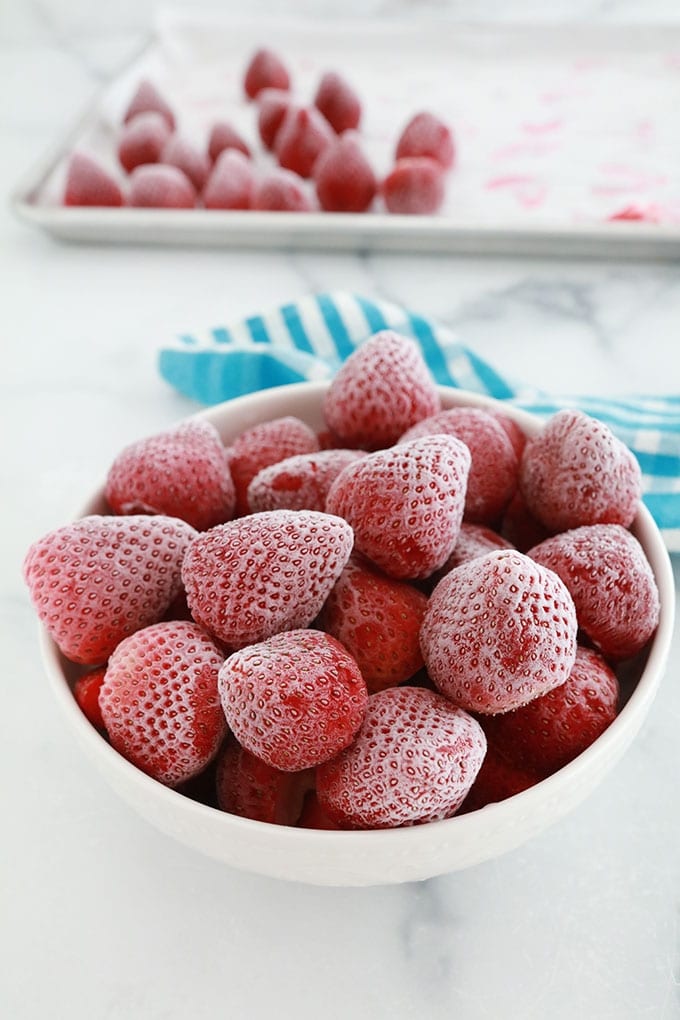 Fraises congelées dans un bol et dans une plaque