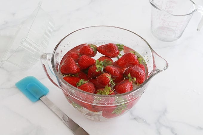 Fraises fraiches trempées dans un mélange d'eau, vinaigre, sel ou bicarbonate de soude