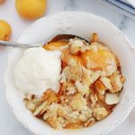 Crumble abricots frais amandes et boule de crème glacée dans un bol