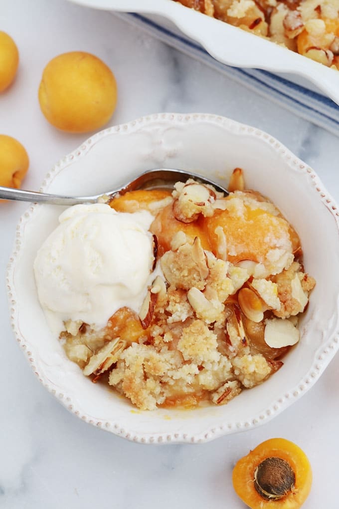 Crumble abricots frais amandes et boule de crème glacée dans un bol