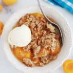 Crumble aux abricots et flocons d'avoine dans un bol avec une boule de glace à la vanille