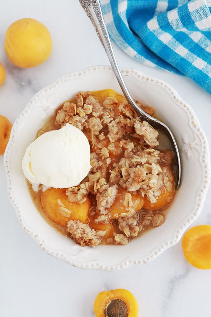 Crumble aux abricots et flocons d'avoine dans un bol avec une boule de glace à la vanille