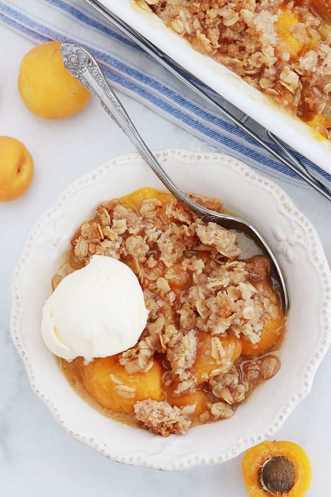 Crumble aux abricots et flocons d'avoine dans un bol avec une boule de glace à la vanille