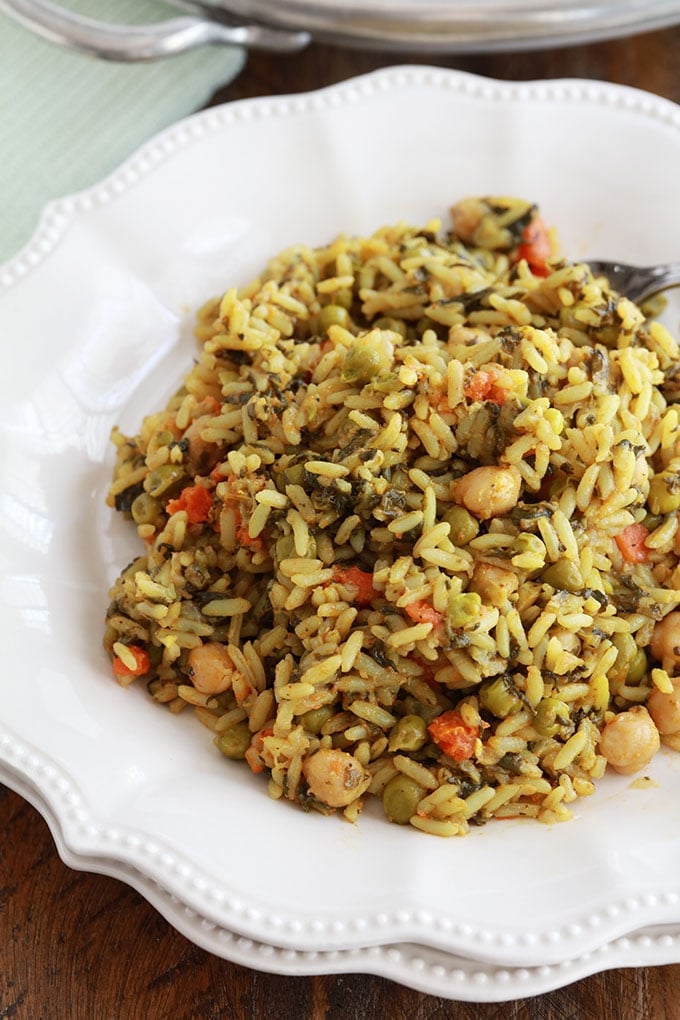 Riz aux légumes cuits à la vapeur servi dans une assiette (pois chiches, épinards, petits pois, carottes, oignons, ail, épices, huile d'olive)