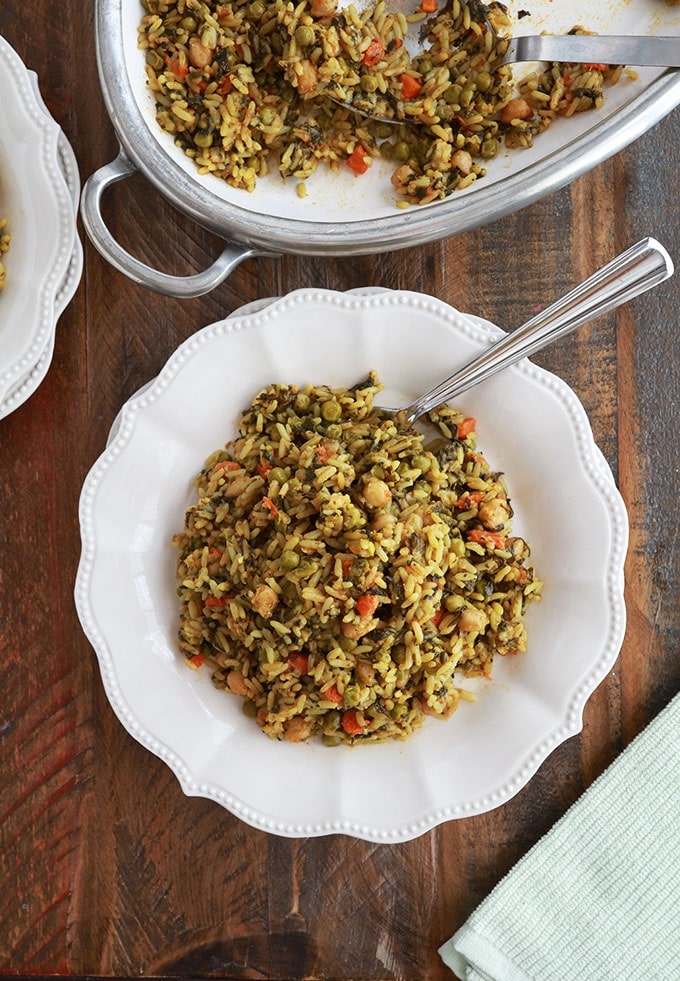 Riz aux légumes cuits à la vapeur servi dans une assiette (pois chiches, épinards, petits pois, carottes, oignons, ail, épices, huile d'olive)