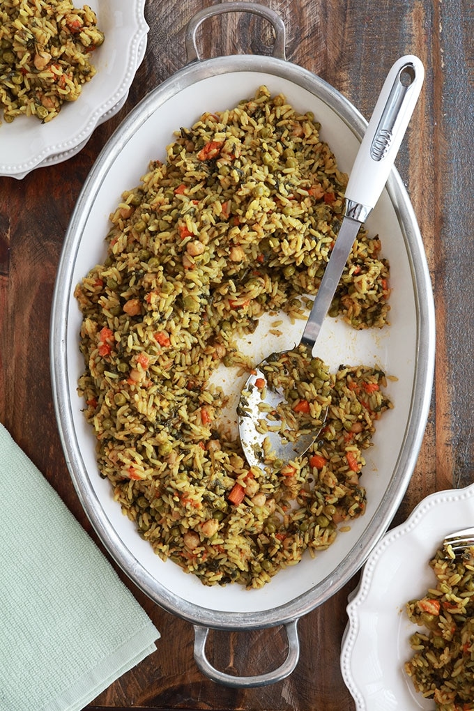 Riz aux légumes cuits à la vapeur servi dans un grand plat (pois chiches, épinards, petits pois, carottes, oignons, ail, épices, huile d'olive)