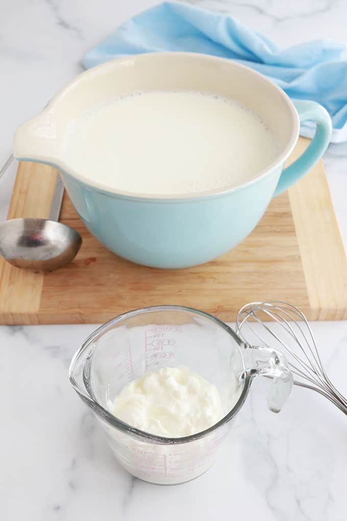 Lait chauffe dans un bol et un peu de yaourt dans une tasse