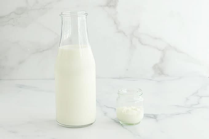 Lait dans une bouteille et un peu de yaourt dans un petit pot