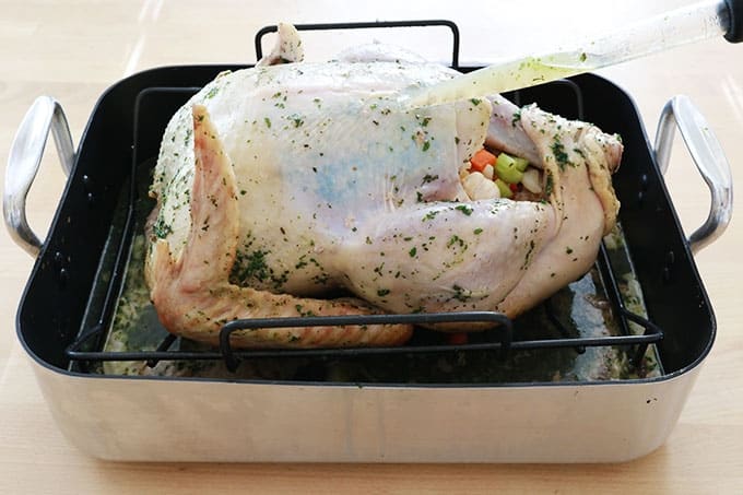 Dinde dans un plat à rôtir arrosée de jus de cuisson