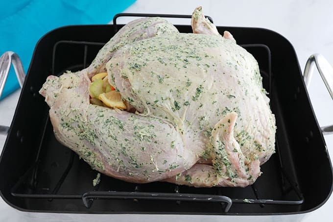 Dans un plat à rôtir, dinde farcie avec des légumes et assaisonnée de beurre aux herbes