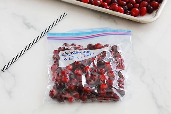Cranberries (canneberges) pré-congelées dans un sac de congélation dont l'air est vidé avec une paille