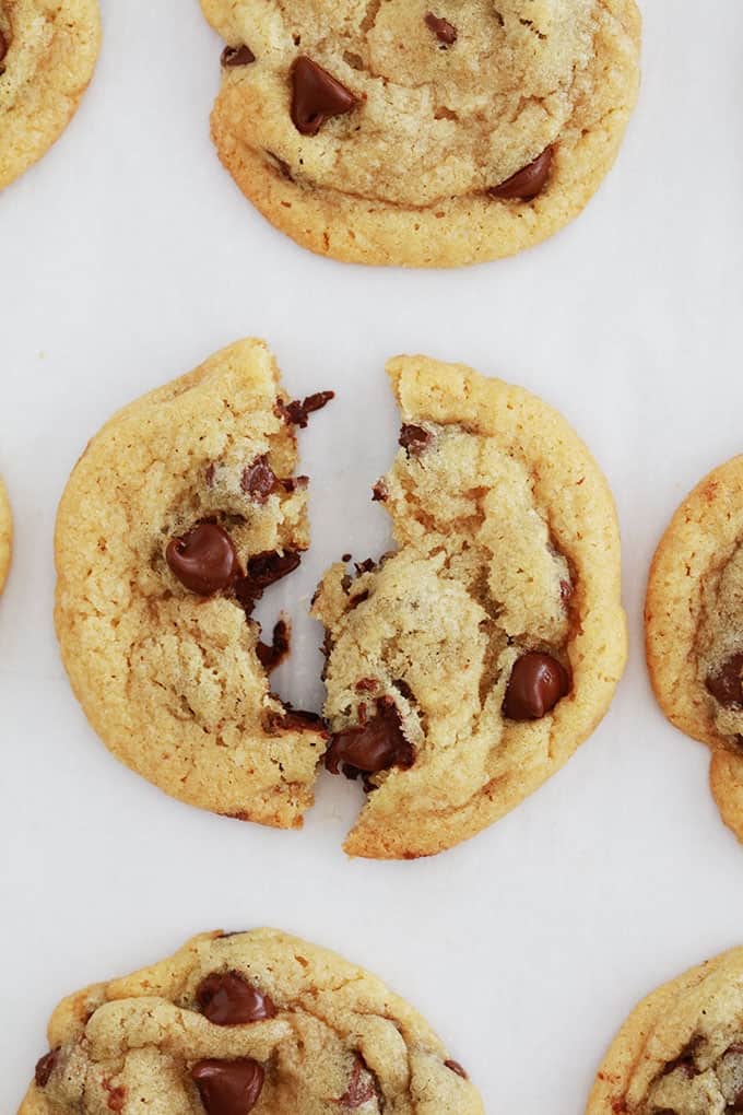 Cookie aux pépites de chocolat encore chaud coupé en deux sur une plaque de cuisson