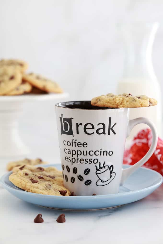 Cookies aux pepites de chocolat americains sur une tasse et dans une assiette servis avec du lait