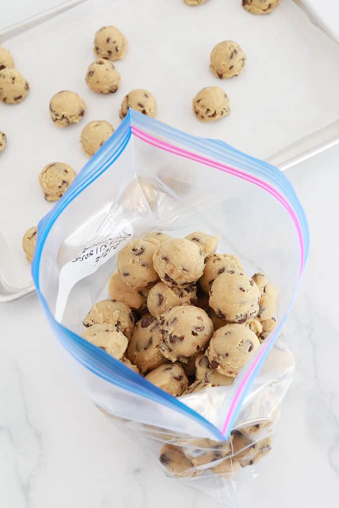 Boules de pâte à cookies aux pépites de chocolat fermes et solides rangées dans un sac de congélation prêtes à être congelées