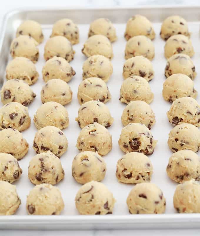 Boules de pâte à cookies aux pépites de chocolat fermes et solides sur une plaque prêtes à être congelées