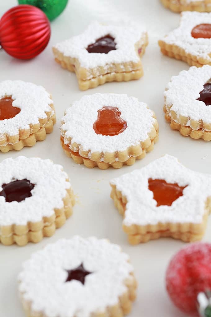 Sur un grand plateau, des biscuits sablés de Noel à la confiture de framboise et confiture d'abricot.