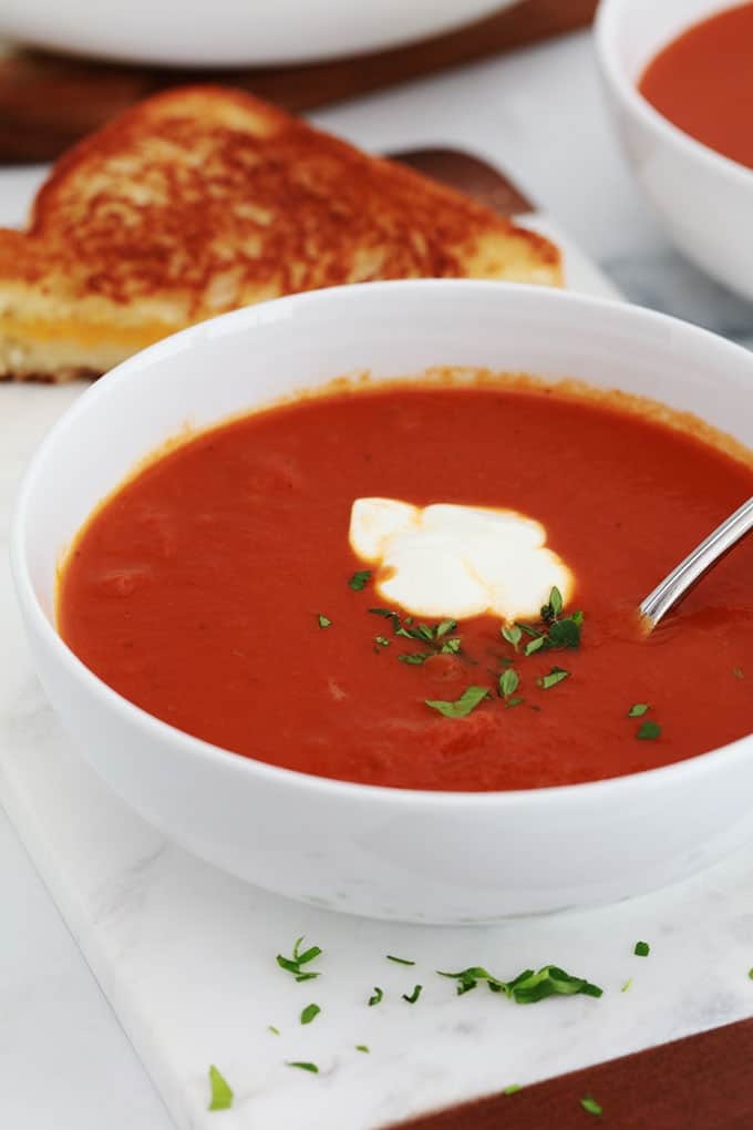 Soupe tomate dans un bol servie avec un sandwich au fromage fondu